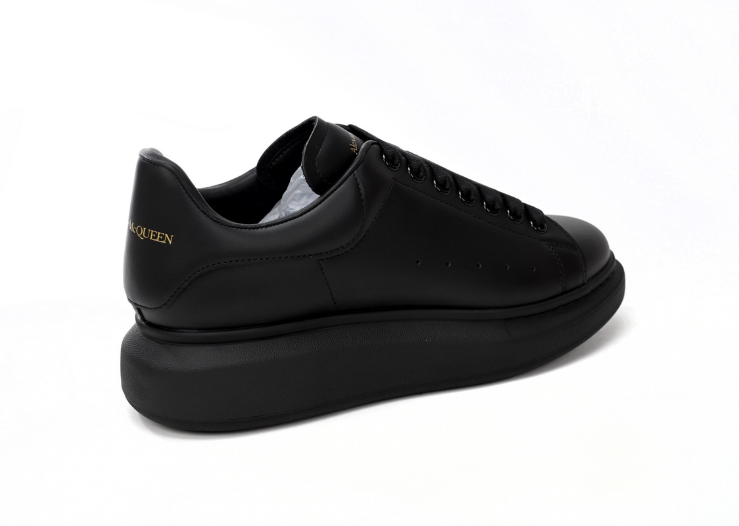 Den Alexander McQueen iwwerdriwwenen Sneaker all schwaarz